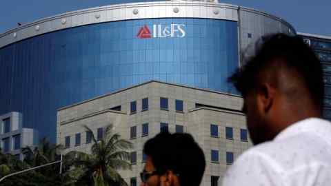 FILE PHOTO: People walk past a building of IL&FS (Infrastructure Leasing and Financial Services Ltd.) outside its headquarters in Mumbai, India, September 25, 2018. REUTERS/Francis Mascarenhas/File Photo