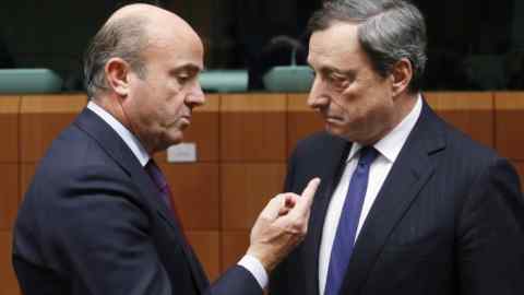 Spain's Economy Minister Luis de Guindos talks to European Central Bank (ECB) President Mario Draghi (R) during a eurozone finance ministers meeting in Brussels December 17, 2013. Euro zone finance ministers face difficult talks over their plans for a banking union on Tuesday, including how to pay for the winding up of troubled banks, a deeply divisive issue on which Germany has dug in its heels. REUTERS/Francois Lenoir (BELGIUM - Tags: POLITICS BUSINESS) - GM1E9CI09ZQ01