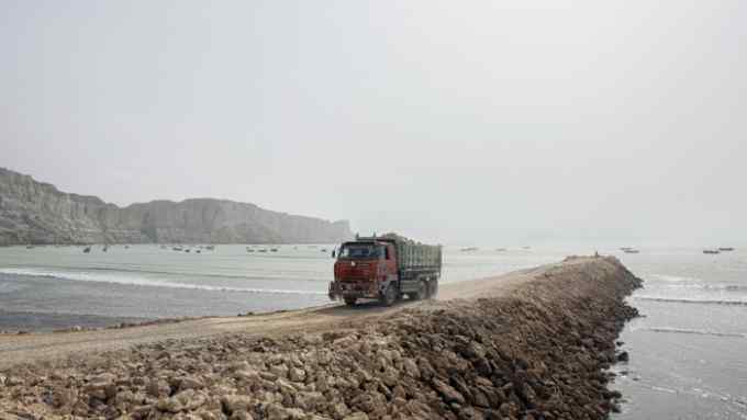 A truck reverses while delivering rocks to a development site on Marine Drive in Gwadar, Balochistan, Pakistan, on Wednesday, Aug. 3, 2016. Gwadar is the cornerstone of Chinese President Xi Jinping's so-called One Belt, One Road project to rebuild the ancient Silk Road, a trading route connecting China to the Arabian Sea that slices through the Himalayas and crosses deserts and disputed territory to reach this ancient fishing port, about 500 miles by boat from Dubai. Photographer: Asim Hafeez/Bloomberg
