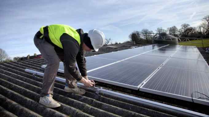 Jake Beautyman installs solar panels on a barn roof on Grange farm, near Balcombe. The installation is part of an initiative by local residents in Balcombe to encourage more people to use renewable energy rather than energy based on carbon such as fracking. The initaitive is called Repowerbalcombe and is supported by the charity 10:10. (Photo by In Pictures Ltd./Corbis via Getty Images)