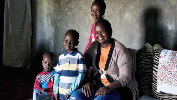 Mary Muthengi, age 32, sits for a portrait with her three children in the living room of their home in Machakos, Kenya, November 15, 2018. Mary took out a Nyumba Smart Loan to help with the construction of her new home. Habitat for Humanity's Center for Innovation in Shelter and Finance gave technical support to the Kenya Women Microfinance Bank, or KWFT, to develop the microfinance product Nyumba Smart Loan.