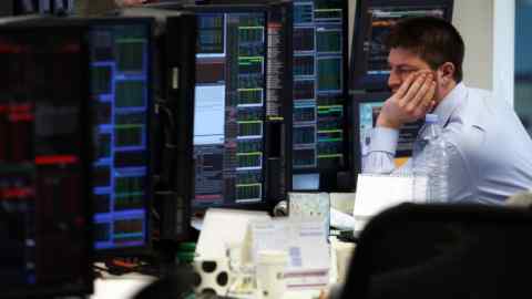 A trader reacts as he monitors financial information on computer screens on the trading floor at Panmure Gordon & Co. in London, U.K., on Friday, Jan. 22, 2016. At least 40 stock markets around the world with a total value of $27 trillion are in bear territory, as investors witness the worst start to a year on record. Photographer: Chris Ratcliffe/Bloomberg