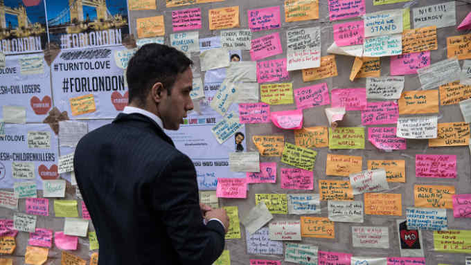 A man views messages of support and condolence on a plinth on London Bridge following Saturday's terror attack, on June 8, 2017 in London, England.