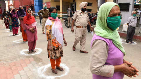 People maintain the recommended distance while waiting to receive free grocery items distributed by police officials during a government-imposed nationwide lockdown as a preventive measure against the COVID-19 novel coronavirus in Amritsar on March 30, 2020. (Photo by NARINDER NANU / AFP) (Photo by NARINDER NANU/AFP via Getty Images)