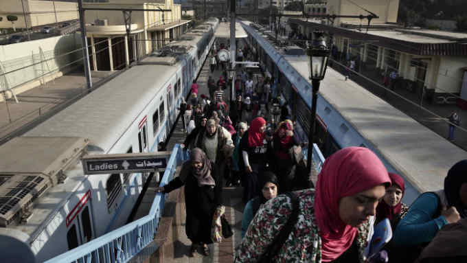 In this Thursday, Oct. 27, 2016 photo, Egyptian women exit a metro station in Cairo, Egypt. On Thursday, Nov. 3, 2016, Egypt devalued its currency by 48 percent, meeting a key demand set by the International Monetary Fund in exchange for a $12 billion loan over three years to overhaul the country's ailing economy. The much heralded decision by the Egyptian Central Bank to devalue the pound followed a sharp and sudden decline this week in the value of the dollar in the unofficial market, plunging from an all-time high of 18.25 pounds to around 13 to the U.S. currency. (AP Photo/Nariman El-Mofty)