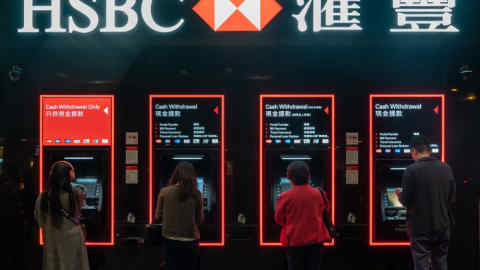 Customers use automated teller machines (ATM) at an HSBC Holdings Plc bank branch at night in Hong Kong, China, on Saturday, Feb 16, 2019. HSBC is scheduled to release full year earnings results on Feb. 19. Photographer: Anthony Kwan/Bloomberg