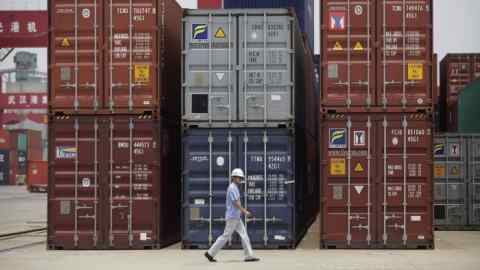 An employee walks past shipping containers at a port near Yangtze River in Wuhan...An employee walks past shipping containers at a port near Yangtze River in Wuhan, Hubei province July 10, 2012. China's June trade data on Tuesday stoked anxiety about the strength of domestic demand in the world's second biggest economy as imports rose at only half the pace expected, signalling a need for Beijing to do more to bolster growth. REUTERS/Stringer (CHINA - Tags: BUSINESS) CHINA OUT. NO COMMERCIAL OR EDITORIAL SALES IN CHINA