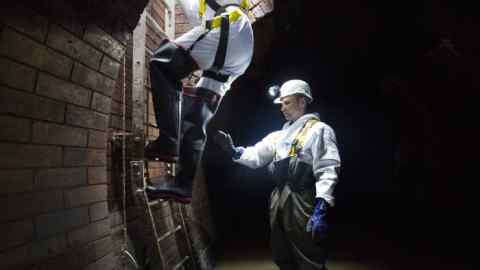 LONDON, ENGLAND - MAY 25: Sewer worker Harry Calder helps lower a visitor into the Northern Outfall Sewer at Wick Lane depot on May 25, 2016 in London, England. The sewer was designed by British engineer Joseph Bazalgette following the 'Great Stink' of 1858 and is today worked on by sewer technicians known as 'Flushers'. Thames Water marks Sewage Week this week with a series of events inviting members of the public down into the underground sewer network and around the Abbey Mills pumping station in east London. (Photo by Jack Taylor/Getty Images)