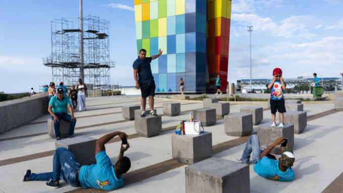 Visitors take advantage of a photo opportunity at La Ventana al mundo, a new piece of public art in Barranquilla