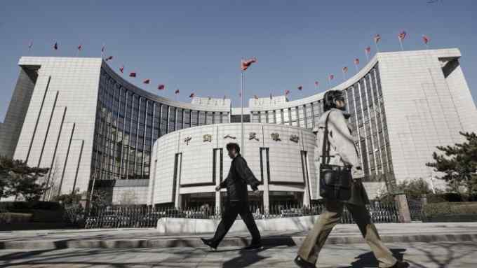 Pedestrians walk past the People's Bank of China (PBOC) headquarters in Beijing, China, on Thursday, March 9, 2017. China's central bank plans to apply a stricter method for assessing banks' capital as part of efforts to contain financial-sector risks, people with knowledge of the matter said. Photographer: Qilai Shen/Bloomberg