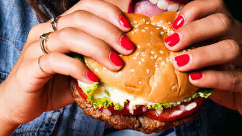 woman about to bite into a burger