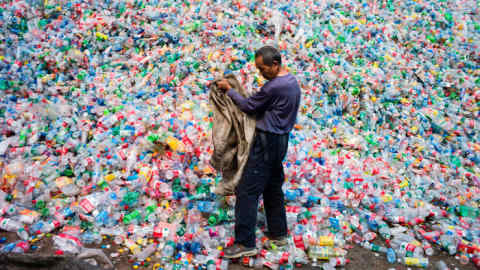 TOPSHOT - This photo taken on September 17, 2015 shows a Chinese labourer sorting out plastic bottles for recycling in Dong Xiao Kou village, on the outskirt of Beijing. China is the world's biggest emitter of the greenhouse gases that cause climate change, and a crucial player in the global gathering finishing on December 11 in Paris, where nations have been trying to thrash out a plan to limit dangerous global warming. The 195-nation UN climate rescue talks in the French capital have been billed as the last chance to avert worst-case-scenario climate change impacts: increasingly severe drought, floods and storms, as well as island-engulfing rising seas. AFP PHOTO / FRED DUFOUR / AFP PHOTO / FRED DUFOUR (Photo credit should read FRED DUFOUR/AFP/Getty Images)