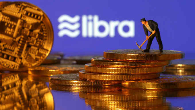 A small toy figure stands on representations of virtual currency in front of the Libra logo in this illustration picture, June 21, 2019. REUTERS/Dado Ruvic/Illustration