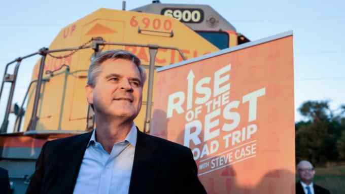 Entrepreneur Steve Case poses in front of a Union Pacific locomotive as he kicks off his &quot;Rise of the Rest&quot; startup bus tour at a stop in Omaha, Neb., Monday, Oct. 3, 2016. &quot;Rise of the Rest&quot; is a nationwide effort that works closely with and invests in entrepreneurs and emerging startups. (AP Photo/Nati Harnik)