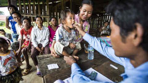 At a malaria awareness event in a school in Pailin region, Cambodia, a young girl receives her first treatment on the spot after having been tested positive for malaria.