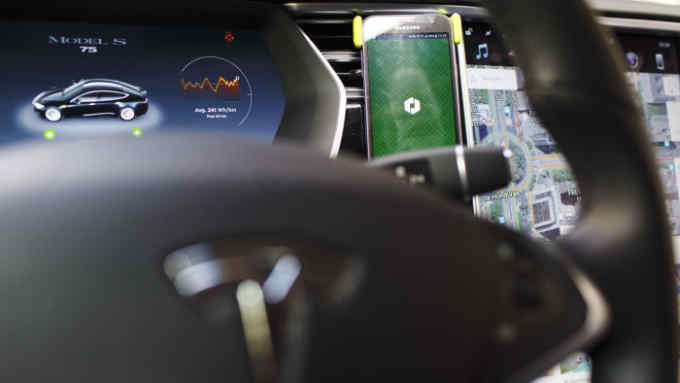 An Uber Technologies Inc. app sits on a smartphone inside a Tesla Motors Inc. Model S electric automobile in Madrid, Spain, on Friday, Jan. 13, 2017. Ride-hailing service Uber Technologies has launched its first electric car taxi service in Madrid, operating a fleet of Tesla Model S electric vehicles. Photographer: Angel Navarrete/Bloomberg