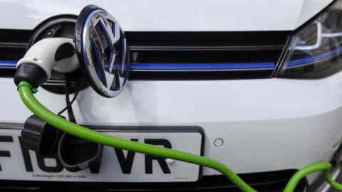 A charging plug sits next to a VW badge cover in the port of a Volkswagen AG GTE Golf hybrid automobile at a charging station in London U.K., on Thursday, Aug. 10, 2017. The U.K. government plans to invest more than 800 million pounds ($1 billion) in new driverless and zero-emission vehicle technology as it seeks to boost its economy while leaving the European Union. Photographer: Luke MacGregor/Bloomberg