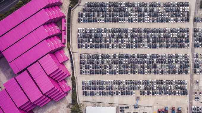 Vehicles stand at a port in this aerial photograph taken above Shanghai, China, on Monday, April 30, 2018. China won't succumb to &quot;threats&quot; from the U.S., a senior government official said, hours before talks are set to begin Thursday with a delegation of the Trump administration's top trade policy officials. Photographer: Qilai Shen/Bloomberg