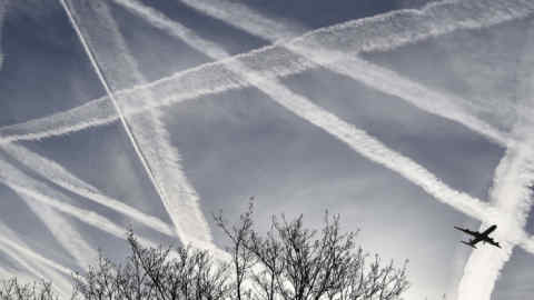 FILE PHOTO --  A passenger plane flies through aircraft contrails in the skies near Heathrow Airport in London, Britain, April 12, 2015. REUTERS/Toby Melville/File Photo