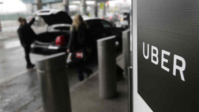 In this March 15, 2017, file photo, a sign marks a pick up point for the Uber car service at LaGuardia Airport in New York. (AP Photo/Seth Wenig, File)