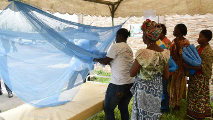 People show how to put a mosquito net on a bed during a free insecticide-treated mosquito nets distribution on April 24, 2015 at the town hall in the Port-Bouet popular district of Abidjan, on the eve of the World Malaria Day on April 25, 2015 as the Ivory Coast's ministry of Health in collaboration with the UNICEF and Global Fund for HIV launched in Abidjan a distribution of mosquito net in the prevention of the desease. Malaria kills on average 7 children every hour in Ivory Coats and about 1,200 children in sub-Saharan Africa per day. AFP PHOTO/ SIA KAMBOU (Photo credit should read SIA KAMBOU/AFP/Getty Images)
