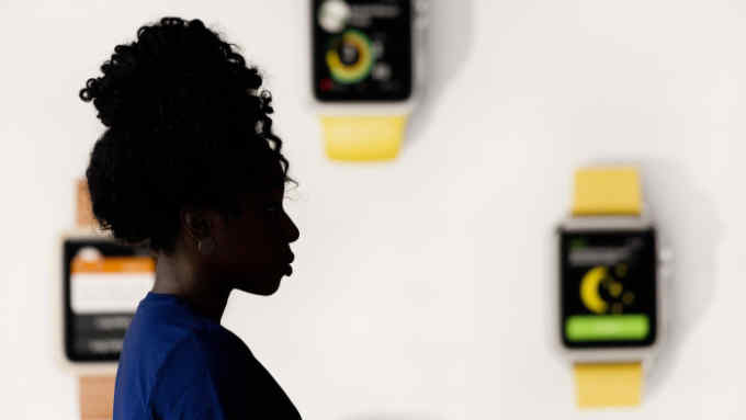 An Apple employee stands next to a display at a new Apple Store, Thursday, July 28, 2016, in Brooklyn's Williamsburg section, in New York. The store opens to the public Saturday. (AP Photo/Mark Lennihan)