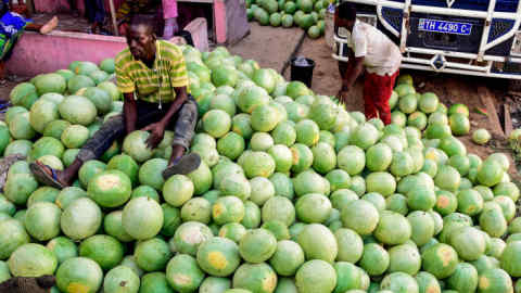 A vendor sits on a pile of water melons at a market in Pikine, a suburb of Dakar on October 25, 2017. Cultivated in the Senegalese countryside, the water melon trade has increased in recent years, becoming an important source of income for many farmers. / AFP PHOTO / SEYLLOU (Photo credit should read SEYLLOU/AFP/Getty Images)
