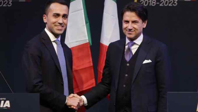 In this photo taken on Thursday, March 1, 2018, Giuseppe Conte, right, shakes hands with leader of the Five-Star Movement, Luigi Di Maio, during a meeting in Rome. Italian media describe Conte as most likely to be the choice of Italy's main populist leaders to head the coalition government they hope to form. (AP Photo/Alessandra Tarantino)
