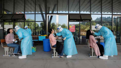Medical workers from a hospital collect swabs from high school teachers for nucleic acid tests at a school, following the coronavirus disease (COVID-19) outbreak, in Yichang, Hubei province, China April 27, 2020. China Daily via REUTERS ATTENTION EDITORS - THIS IMAGE WAS PROVIDED BY A THIRD PARTY. CHINA OUT. TPX IMAGES OF THE DAY