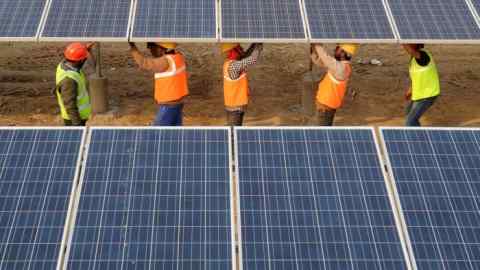 Indian workers construct part of the France-India Solar Direct Punjab Solar Park project in Muradwala