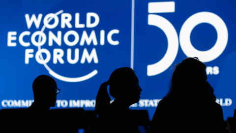 A screen silhouettes attendees inside the Congress Center ahead of the World Economic Forum (WEF) in Davos, Switzerland, on Sunday, Jan. 19, 2020. World leaders, influential executives, bankers and policy makers attend the 50th annual meeting of the World Economic Forum in Davos from Jan. 21 - 24. Photographer: Jason Alden/Bloomberg