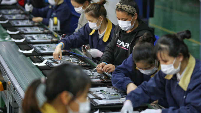 Employees, wearing masks, work on a production line manufacturing display monitors at a TPV factory in Wuhan, Hubei province, the epicentre of the novel coronavirus disease (COVID-19) outbreak in China, April 7, 2020. China Daily via REUTERS ATTENTION EDITORS - THIS IMAGE WAS PROVIDED BY A THIRD PARTY. CHINA OUT.