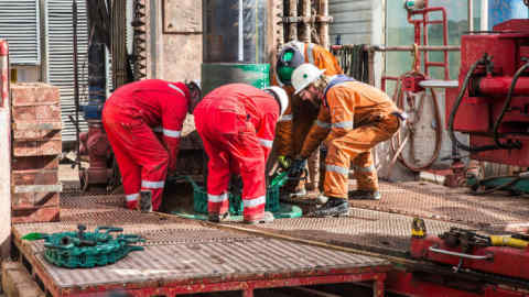 Workers connect sections of pipe together on the drilling platform at the Preston New Road pilot gas well site, operated by Cuadrilla Resources Ltd., near Blackpool, U.K., on Tuesday, Sept. 19, 2017. Cuadrilla started drilling the pilot well that is expected to reach depth of 3,500 meters, a core sample will be taken from the well and examined to determine where to drill the horizontal well it intends to frack. Photographer: Matthew Lloyd/Bloomberg