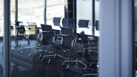 Empty chairs in large conference room, in modern office space with glass walls