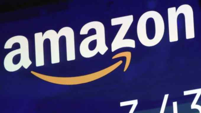FILE - In this Friday, July 27, 2018 file photo, the logo for Amazon is displayed on a screen at the Nasdaq MarketSite. Amazon is facing criticism after its British tax bill fell despite a big jump in sales and profits. Records show Amazon U.K. Services Ltd. faced a 2017 tax bill of 4.6 million pounds ($6 million) but paid 1.7 million pounds ($2.2 million), deferring the rest. Its pre-tax profits for the same period were 72.4 million, almost triple the previous year's 24.3 million. Amazon said Friday, Aug. 3 that it pays &quot;all taxes required in the U.K. and every country where we operate.&quot; (AP Photo/Richard Drew, file)