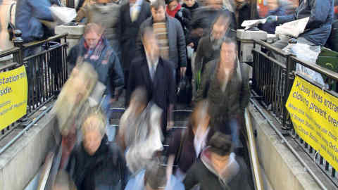 A long exposure image showing Tube travelers being handed free afternoon newspapers travelers as they crowd one of the Oxford Circus entrances during the rush hour, in London, Britain