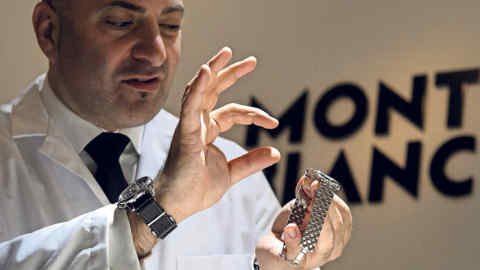 An employee of German manufacturer of writing instruments and watches Montblanc, owned by Richemont, the world's second-largest luxury goods firm shows a new watch model on the opening day of the &quot;Salon International de la Haute Horlogerie&quot; (SIHH), a professional fair in fine watchmaking, on January 19, 2015, in Geneva