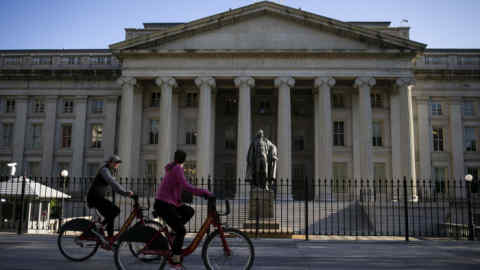 Bicyclists pass the U.S. Treasury building in Washington, D.C., U.S., on Thursday, April 16, 2020. President Donald Trump threatened Wednesday to try to force both houses of Congress to adjourn -- an unprecedented move that would likely raise a constitutional challenge -- so that he can make appointments to government jobs without Senate approval. Photographer: Al Drago/Bloomberg