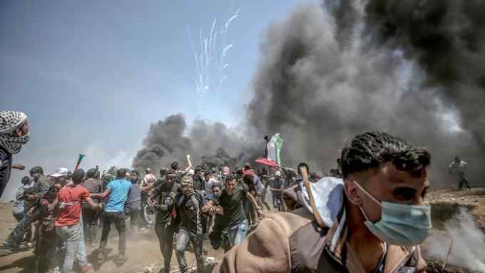 epa06737562 Palestinian protesters run for cover from Israeli tear-gas during clashes after protests near the border with Israel in the east of Gaza Strip, 14 May 2018 (issued 15 May 2018). More protests are expected in the Palestinian territories on 15 May. At least 58 Palestinian protesters were killed and more than 2,000 others were injured at the Gaza-Israeli border during clashes against the US embassy move to Jerusalem as well as marking the Nakba Day. Palestinians are marking the Nakba Day, or the day of the disaster, when more than 700 thousand Palestinians were forcefully expelled from their villages during the war that led to the creation of the state of Israel on 15 May 1948. Protesters call for the right of Palestinians to return to their homeland. EPA/MOHAMMED SABER