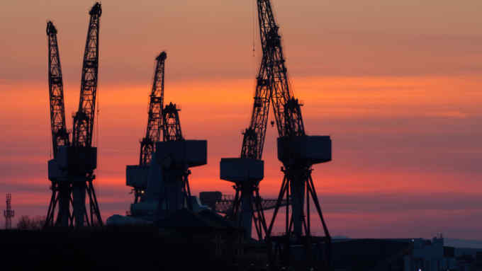 BKHXFB Cranes in the BAE Systems shipyard in Govan on the River Clyde Glasgow at Sunset