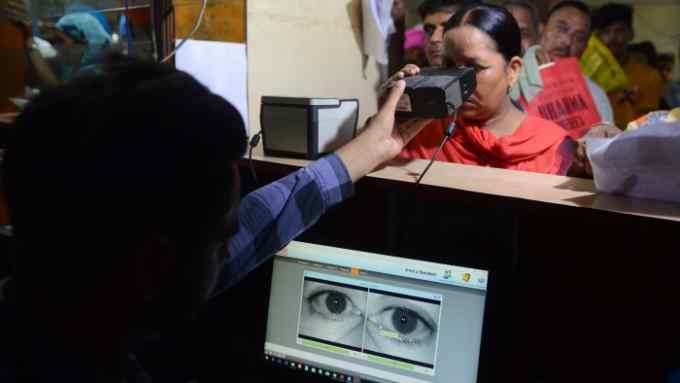 This photo taken on July 17, 2018 shows an Indian woman looking through an optical biometric reader that which scans an individual's iris patterns, during registration for Aadhaar cards (or unique identifier [UID] cards) in Amritsar. - India's top court on September 26 upheld the government's Aadhaar scheme, the world's largest biometric database, but imposed new restrictions on how the personal details of more than one billions citizens in the system can be used. (Photo by NARINDER NANU / AFP) (Photo credit should read NARINDER NANU/AFP/Getty Images)