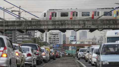 Traffic travels on the Western Express Highway as a train travels across the cable-stayed Metro Bridge on Line 1, operated by the Mumbai Metro One Pvt. (MMOPL), a joint venture controlled by Reliance Industries Ltd., in Mumbai, India, on Friday, June 16, 2017. The expanding mega city's suburban railway is one of the most crowded and among the most dangerous in the world. That's why there's an 800 billion rupee ($12.5 billion) project under way to build a new, rapid transit system that will carry an estimated 7 million more passengers — making it busier than Metros in New York and London. Photographer: Dhiraj Singh/Bloomberg