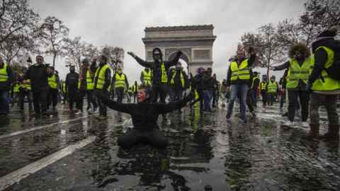 PARIS, FRANCE - DECEMBER 01:  A protester is wounded by a water canon as they clash with riot police during a 'Yellow Vest' demonstration near the Arc de Triomphe on December 1, 2018 in Paris, France. The third 'Yellow Vest' (gilets jaunes) rally in Paris over increased fuel taxes and leadership in the government today caused over 150 arrests in the city with reports of injuries to protesters and security forces from violence that irrupted from the clashes.  (Photo by Veronique de Viguerie/Getty Images)