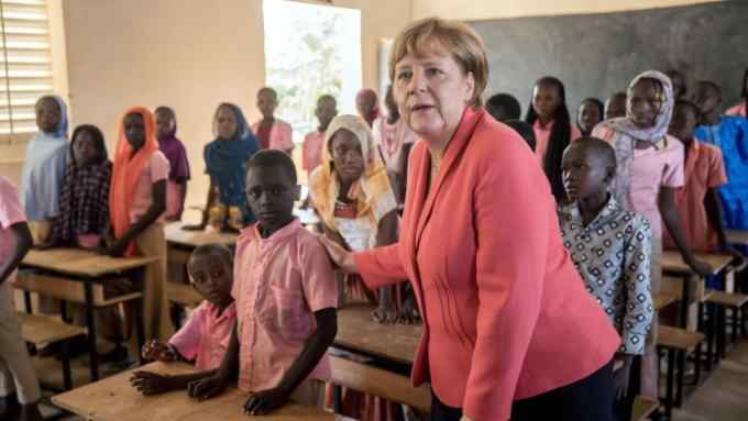 German Chancellor Angela Merkel (CDU) speaks with primary school students from the Goudell II. school in Niamey, Niger, 10 October 2016. Chancellor Merkel is on a three-day trip through Africa with stops in Mali, Niger and Ethiopia. Photo: MICHAEL KAPPELER/dpa