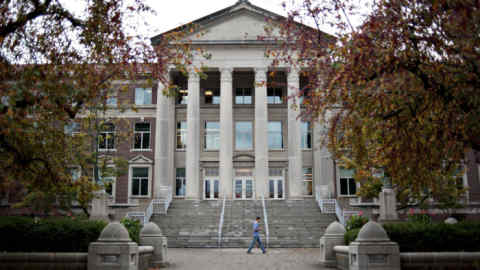 A student walks past the Hovde Hall of Administration building on the campus of Purdue University in West Lafayette, Indiana, U.S., on Monday, Oct. 22, 2012. Photographer: Daniel Acker