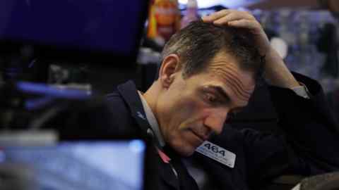 Trader Gregory Rowe prepares for the day's activity on the floor of the New York Stock Exchange, Monday, March 9, 2020. Trading in Wall Street futures has been halted after they fell by more than the daily limit of 5%. (AP Photo/Richard Drew)