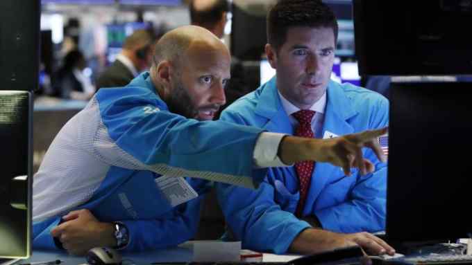 Specialists Meric Greenbaum, left, and Thomas McArdle work on the floor of the New York Stock Exchange, Tuesday, Aug. 6, 2019. Stock markets turned higher on Tuesday as China stabilized its currency after allowing it to depreciate against the dollar in response to President Donald Trump's decision to put more tariffs on Chinese goods. (AP Photo/Richard Drew)