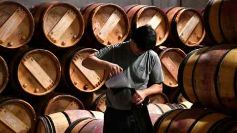 An employee pours wine into bottles in the wine cellar of Chateau Margaux in 2018 in Margaux, near Bordeaux, western  France