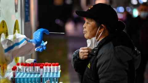 A health worker takes a swab sample from a woman to test for the Covid-19 coronavirus in the Huangpu district in Shanghai