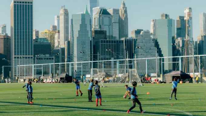 New York City kids playing football with the city in the background
